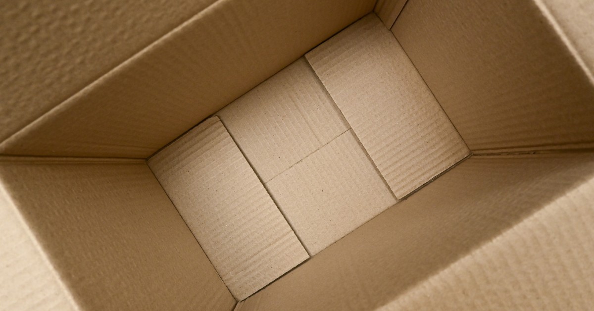 A close-up view inside of a medium-sized brown cardboard box. It is folded open with interior panels.